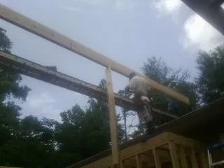 Carpenter setting a ridge beam over a new addition frame — Ice Dam Removal by Roofing Brothers in West Shokan