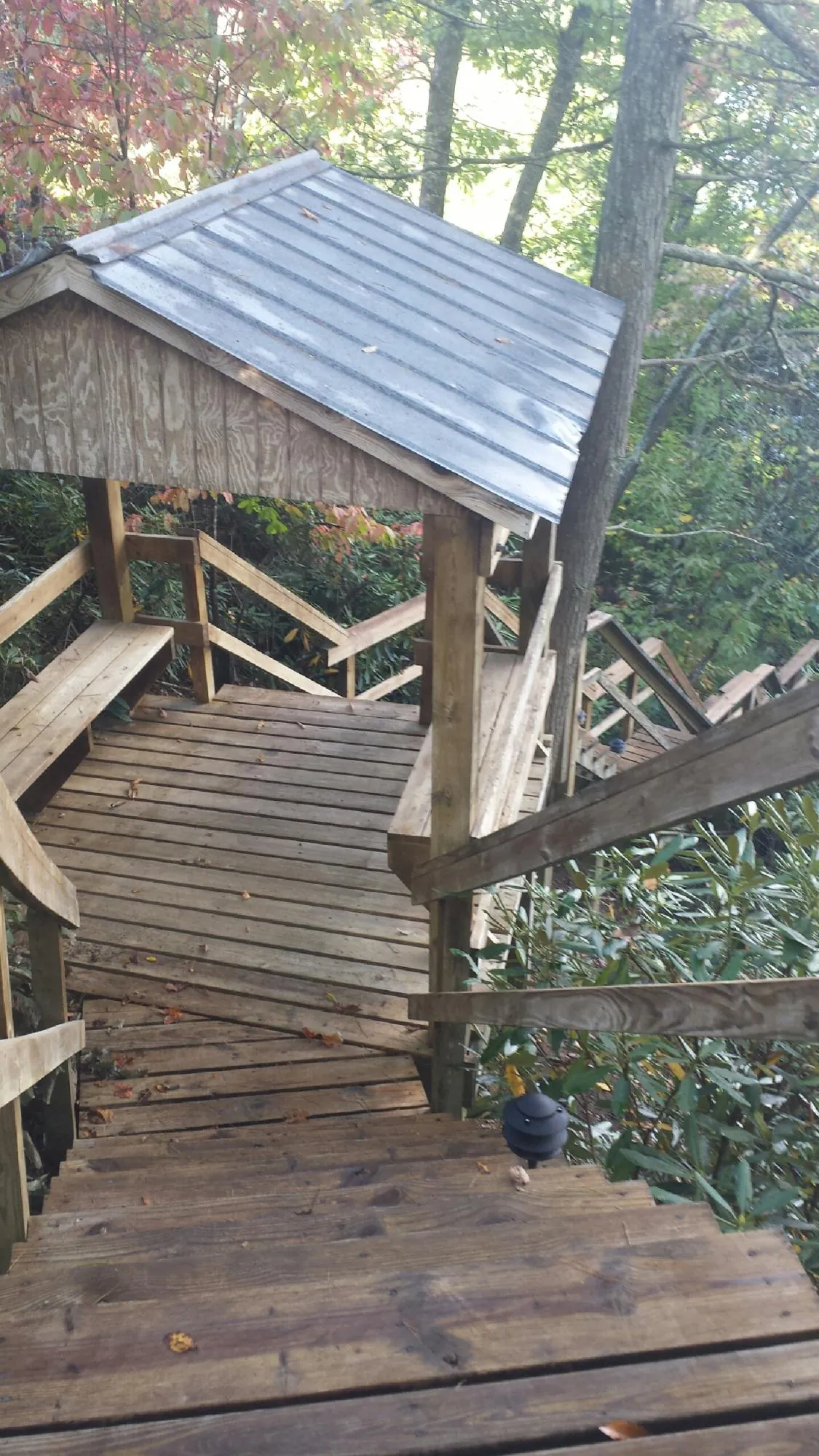 Metal roofed shelter over wooden steps on a wooded walkway — Skylight Repair & Installation work by our crew in West Shokan